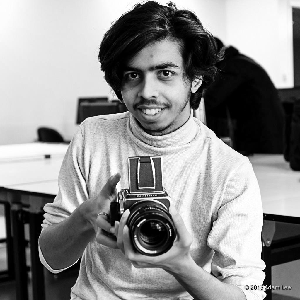 Portrait photo of Syed Minjah Hossain holding camera