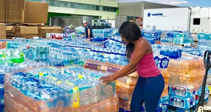 Student with packs of water bottles