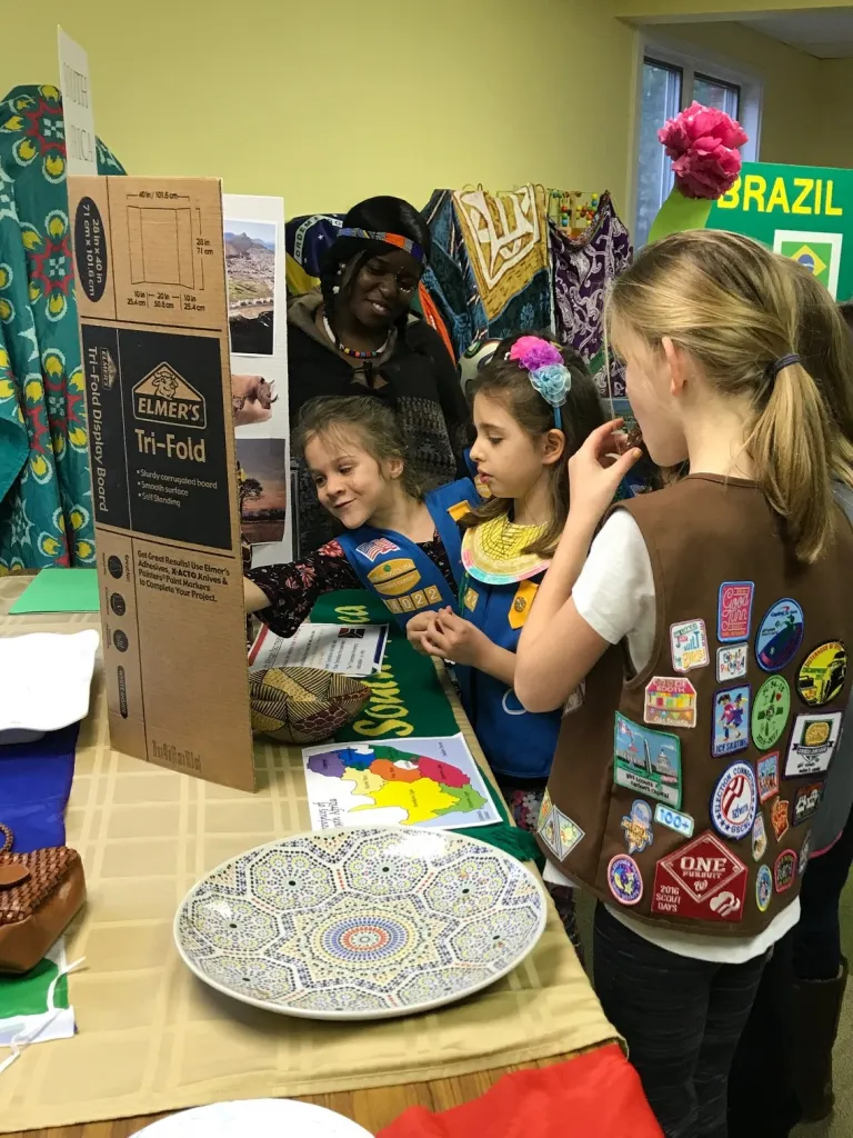Mamello Moloi (South Africa, Northern Virginia Community College, 2017-2018) shows local Girl Scouts her table presentation about her home country, South Africa.