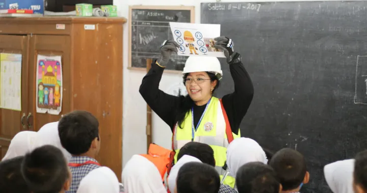 Indonesian CCI alumna Bunga Yuniasari explains the functions of her safety gear to children at an elementary school in Tegal Regency, Central Java. Bunga visited the school to talk about her career as an architectural and civil engineer.