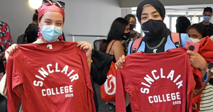 Two CCI students holding Sinclair College shirts