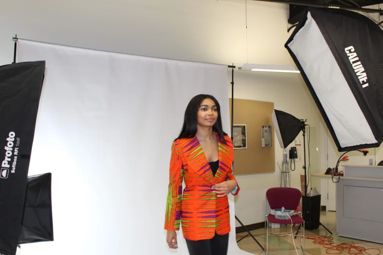 A student model poses in the vibrantly colored jacket crafted by CCI participant Maria Nuhu (Ghana, College of DuPage, Media)