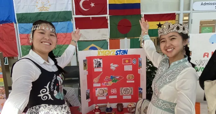 Two students showcasing their table from Kyrgzstan