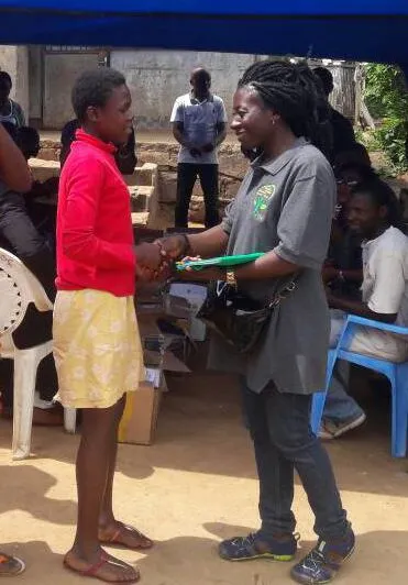 Prodencia (right) delivers donated writing materials and dresses in the Archdiocese of Obala in Yaounde, Cameroon as part of an initiative to promote girls’ education.