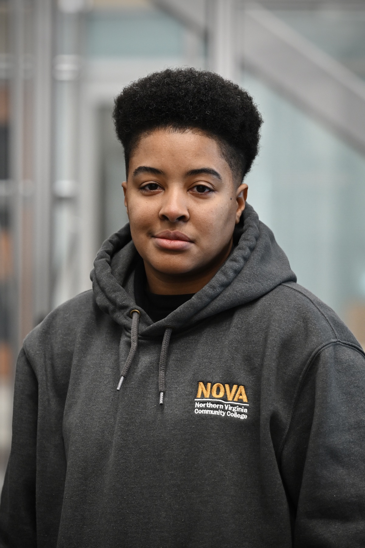 A portrait of Ayrial White smiling at the camera wearing a NOVA hoodie in the data center training facility.