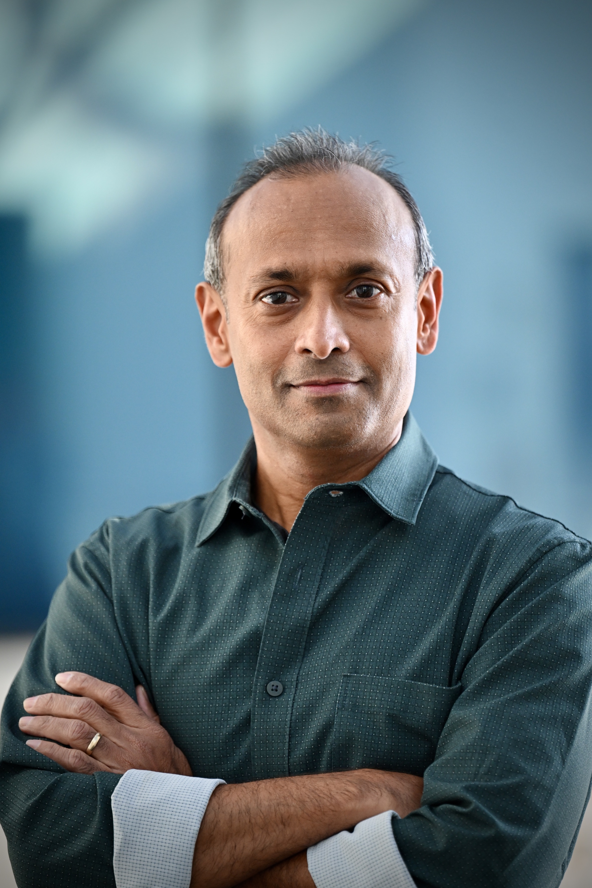 A photo of Nasir Ayoub with folded arms looking at the camera