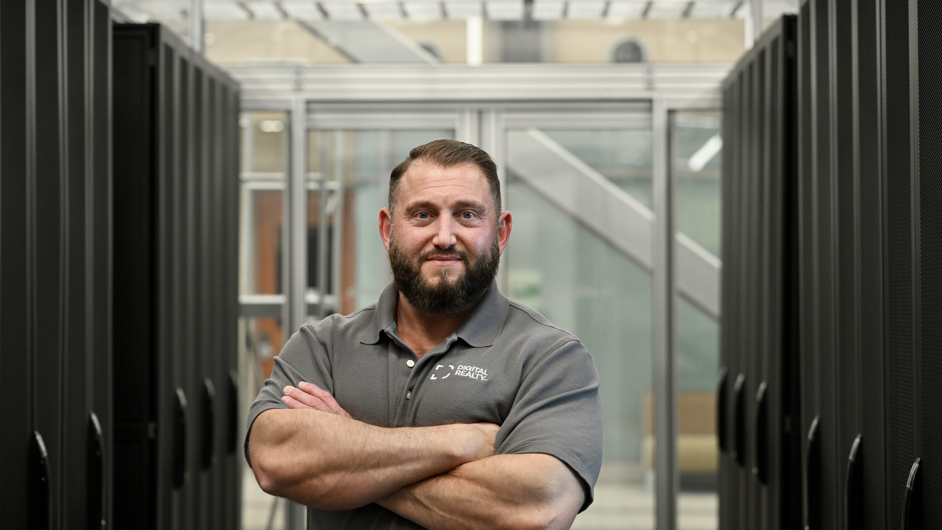 A photo of Ted Bourne with arms folded in a power pose in the data center training facility