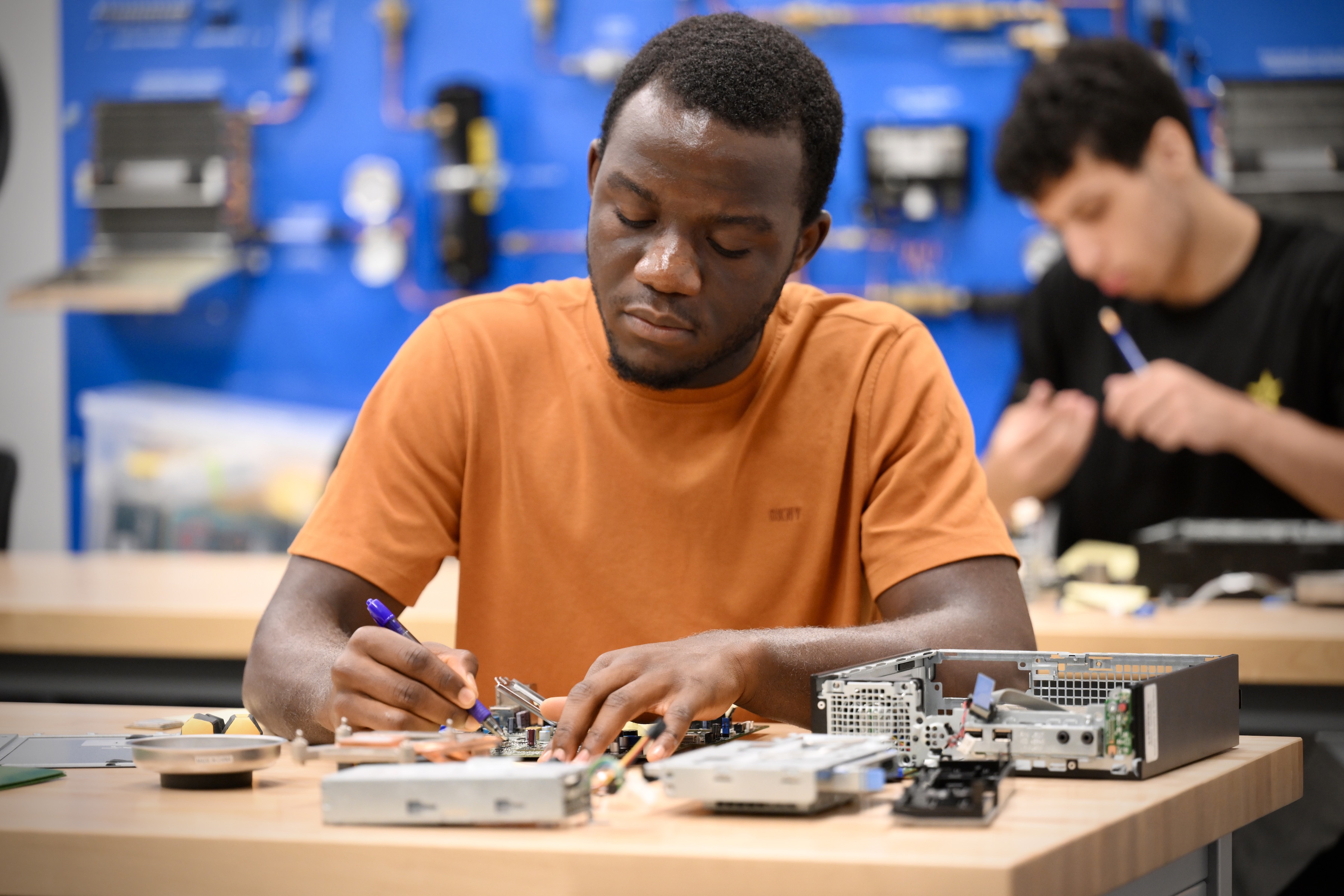 A bridge program student working on computer hardware at the NOVA Woodbridge campus.
